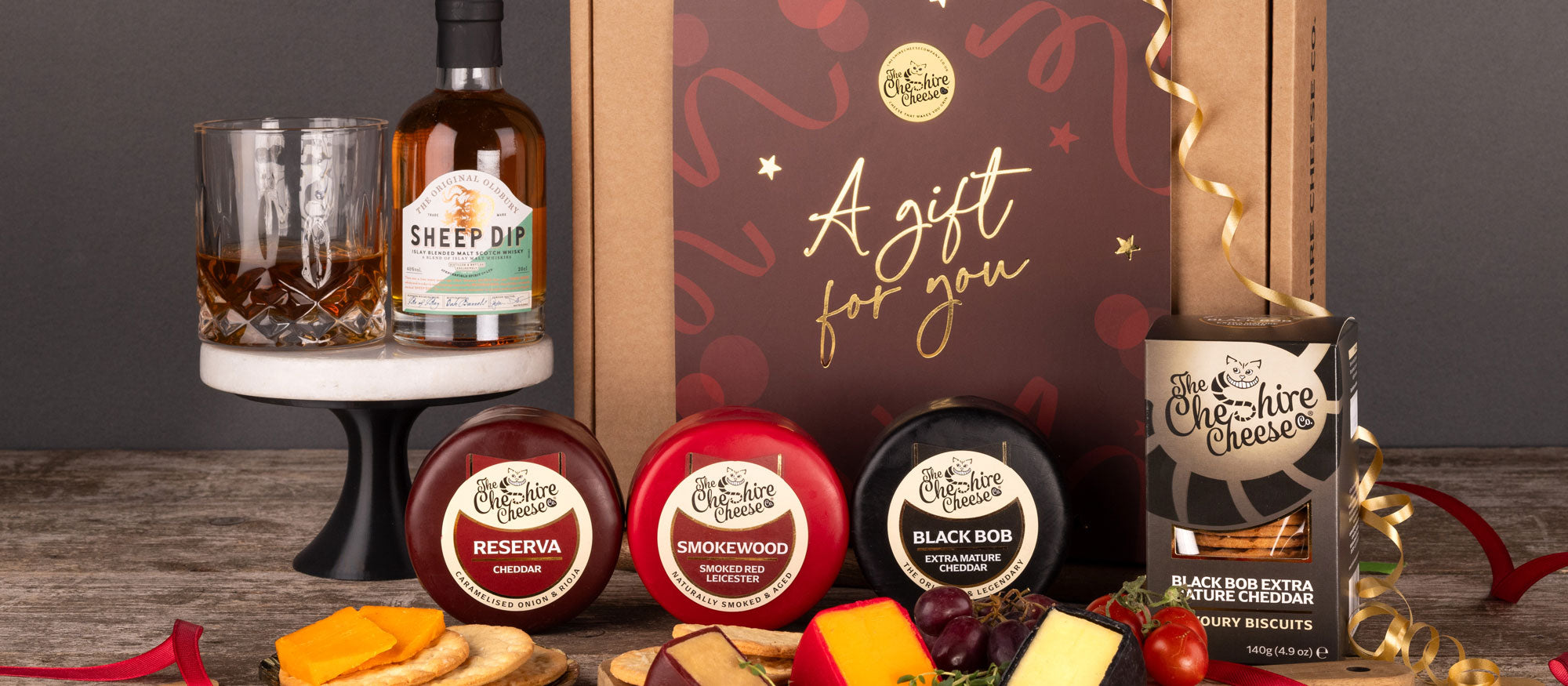 Celebration cheese hamper with waxed truckles and a bottle of whiskey