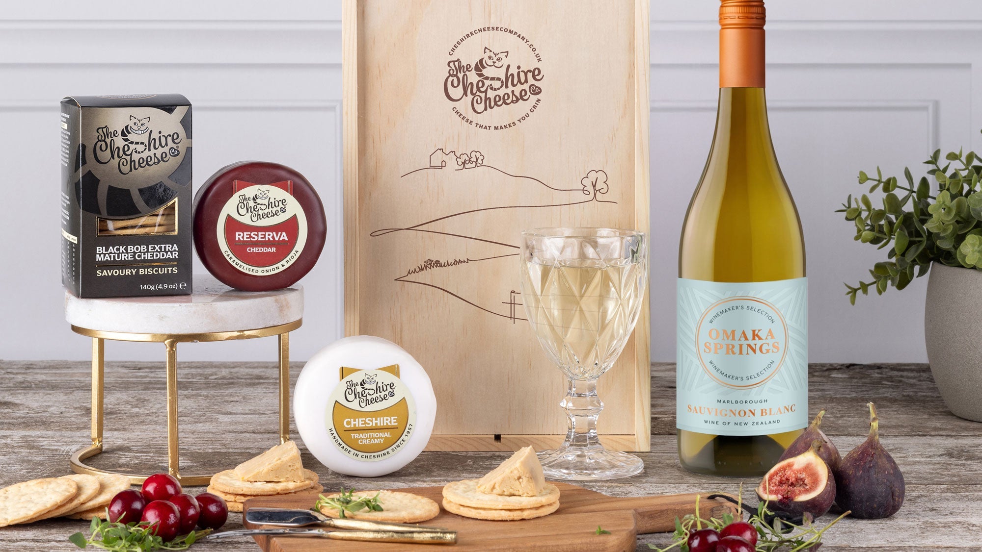 Cheese gift hamper with waxed truckles, crackers and a bottle of white wine